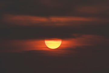 Evening sky time with sun and orange clouds in sunset sky background.Heat wave hot sun, climate change and global warming concept.
