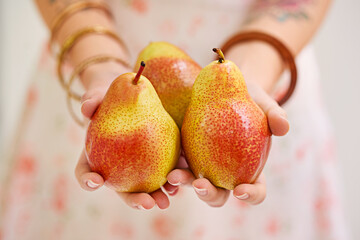 Woman, hands and fruit or pears for health, organic and balanced diet by eating nutrition snacks....