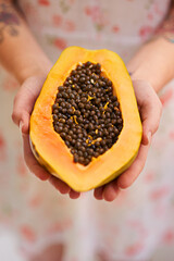 Hands, person and papaya in half with nutrition for healthy eating with seeds, nutrients and wellness. Food, pawpaw and diet with fruit for weight loss with vitamin c for balance with freshness