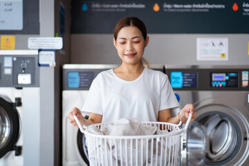 Woman washing clothes at self-service laundry KIOSK.