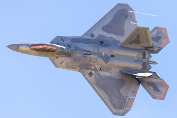 Top view of a F-22 Raptor in beautiful light, in a turn