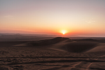 sunset over the dunes in the desert in huacachina