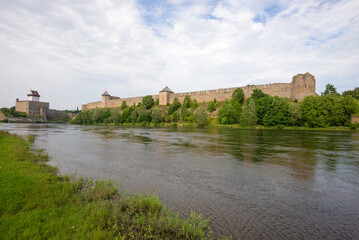 Herman Castle and Ivangorod Fortress on the Narova River on an August day. View from the Estonian side. Border between Estonia and Russia