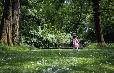 Portrait of a running little girl in the park.