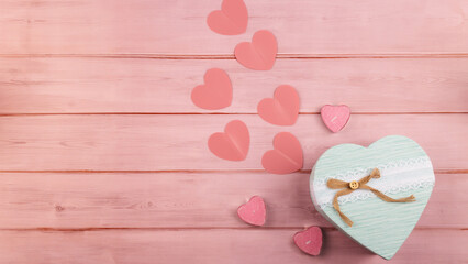 Ideal gift setup for her: top view chic presents, love hearts on a soft pink wooden backdrop, leaving space for your message or ads