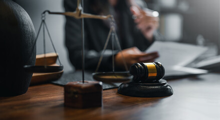 judge, advice, judgement, adviser, justice, lawyer, law, judgment, legal, advocate. A woman is sitting at a desk with a gavel and scales. The woman is wearing a black suit and she is a lawyer. - obrazy, fototapety, plakaty