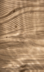 Under water texture light shadows on the beach sand. Close up