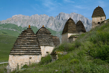 The ancient crypts of the city of the dead Dargavs against the background of the mountains on a sunny June day. North Ossetia-Alania. Russia - 790258841