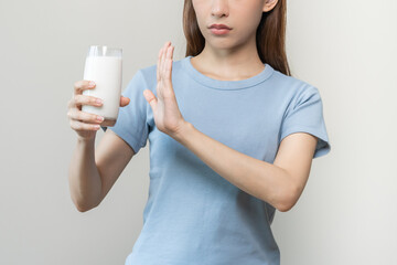 Allergy asian young woman, girl hand in deny, no or push out to avoid for drink milk at home, unhappy and bad stomach ache. Lactose intolerance and dairy food, health problem, belly suffer concept.
