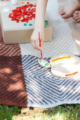 A girl creates an apple out of mosaics in an open space. 