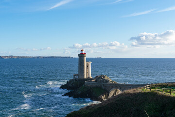 Sous un magnifique ciel bleu, le phare du Petit Minou trône sur son îlot rocheux, majestueux et...
