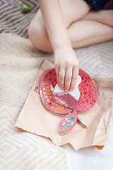 A girl creates an apple out of mosaics in an open space. 