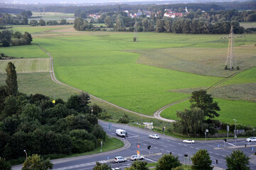 Fototapeta premium Drone view of a road intersection outside the city near a green field with passing cars