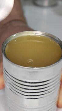 Man opening a tin can of chickpeas, vertical close-up video.