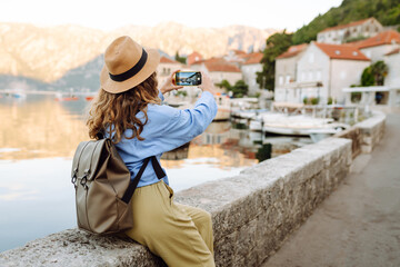 Beautiful female tourist walks the streets and photographed attractions. Lifestyle, travel, rest,...