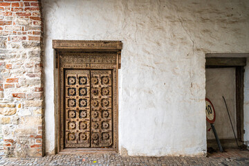 very old wooden door artfully designed in white masonry