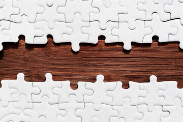 Jigsaw Puzzle with Missing Pieces Revealing Wooden Background