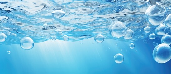 Naklejka na ściany i meble Transparent water bubbles floating in electric blue liquid underwater