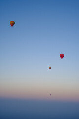 Sunrise in Morocco: A hot air balloon rises over desert dunes, illuminated by the dawn light.