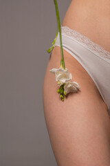 White flower on a woman's thigh. Women's health concept. Youth and beauty. Body care. Natural cosmetics for skin