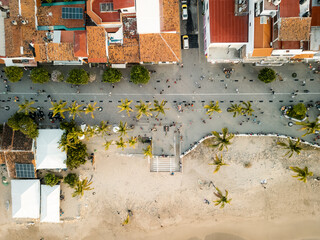 Tourists exploring the boardwalk near beach seen from aerial view of el Malecon Puerto Vallarta Mexico.