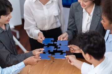 Corporate officer worker collaborate in office, connecting puzzle pieces with report paper on table...