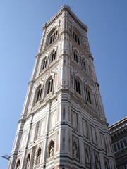 A tower in Florence rises against a light blue sky.