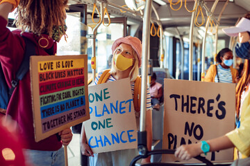 Activists with protest signs about climate change on a bus