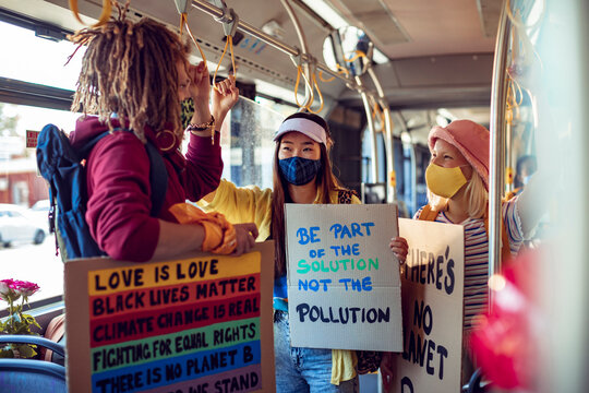 Activists with protest signs about climate change on a bus