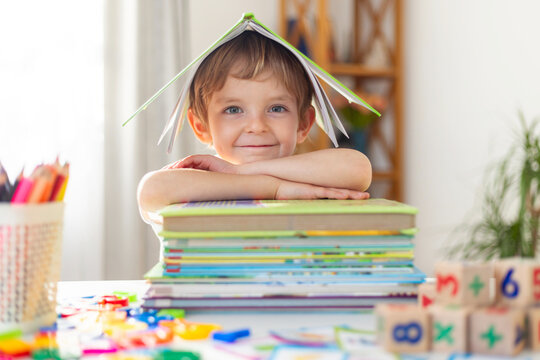 Child with Books Smiling Under Paper Roof