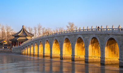 Seventeen-Arch Bridge at sunset with golden color in winter, Summer Palace, Beijing, China