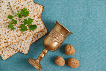 Pesach background. Passover jewish. Matzah, walnuts, parsley on the on the blue background and blank placard.