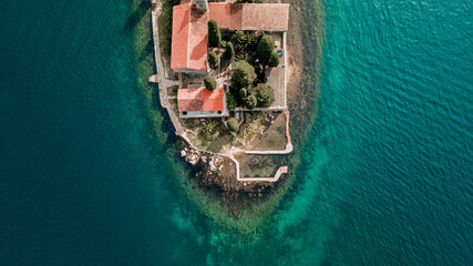 aerial view of a historic island fortress surrounded by turquoise waters under a clear sky