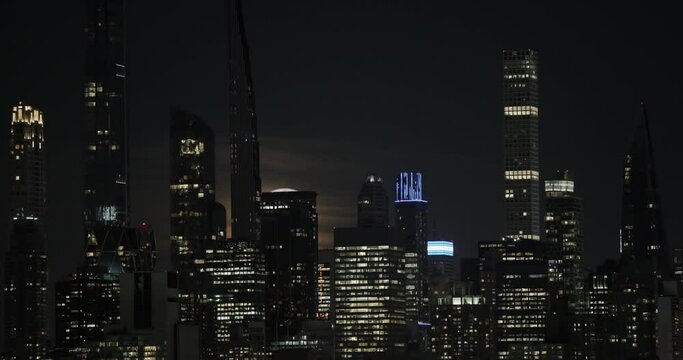 Full Moon Rising Up from Behind Manhattan Skyscrapers