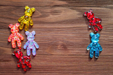 Colorful Bear Figurines with Hearts and Glitter on Wooden Background