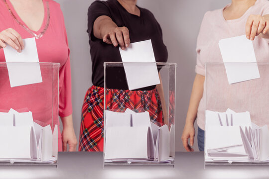 A voter casting a ballot into a ballot box on election day. Referendum, democracy,  plebiscite, voting rights for womenconcept