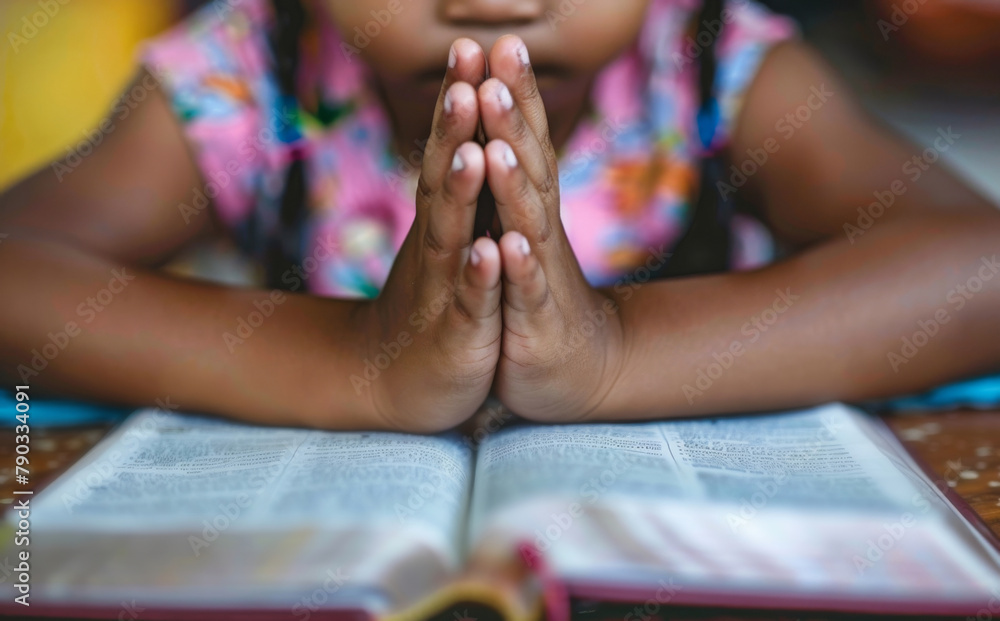 Wall mural Prayer, faith and kid with hands on bible in home for hope, thanks and gratitude to God in gospel. Praise, worship and child with holy book, spiritual respect and children with Christian religion