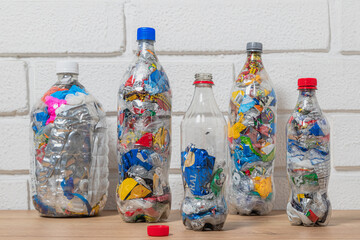 Group of four bottles of PET filled with plastic waste for upcycling and ecobricking