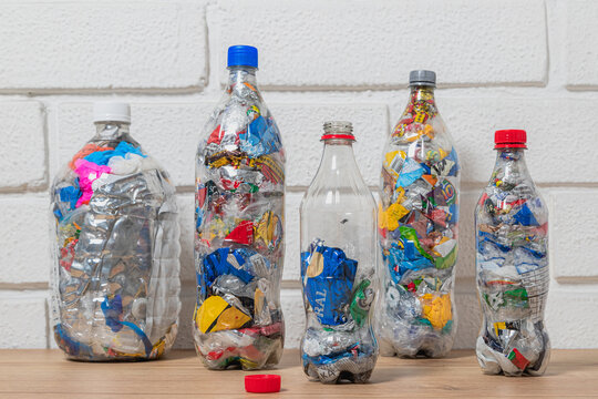 Group of four bottles of PET filled with plastic waste for upcycling and ecobricking