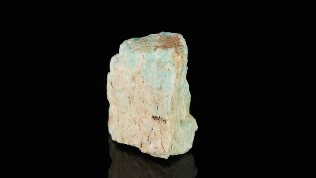 Polished mineral stone Amazonite rotates in a circle on a black background close-up