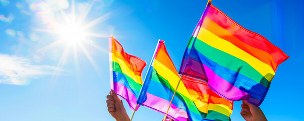 Sky Full of Pride: Multiple Rainbow Flags in Hand
