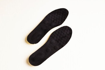 A pair of black colored,orthopedic men's shoe insoles on white surface with copy space
