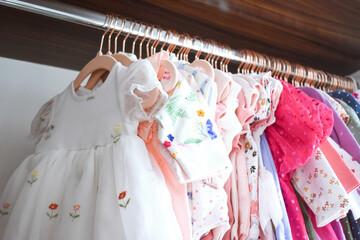 Baby girl clothes hanging in closet