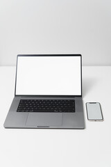 Green laptop screen on white background standing on white desk, laptop screen replacement, home office, work from home, mobile phone with laptop for business, notepad and pen, remote work