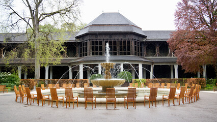 Gradierwerk in Bad Reichenhall im Kurpark mit Springbrunnen bei Regenwetter mit Tulpen und anderen Blumen