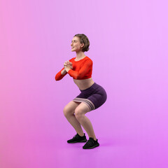 Full body length gaiety shot athletic and sporty young woman with fitness elastic resistance band in squat exercise posture on isolated background. Healthy active and body care lifestyle.