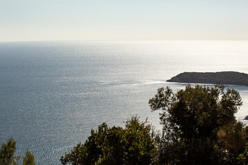 The sea surface of the Adriatic Sea. An island with green trees. View from above. Montenegro....