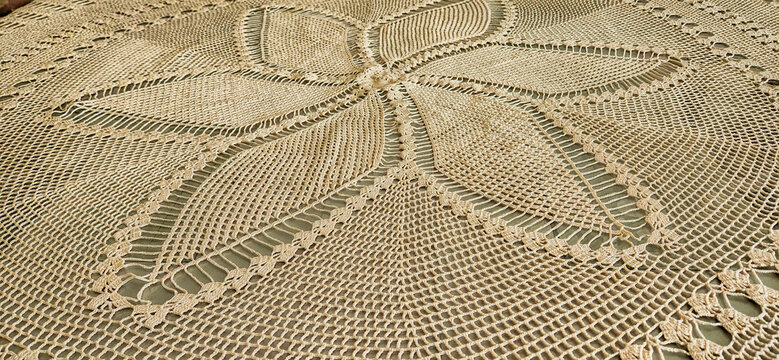 Tablecloth lace with flower motifs, crocheted with cream colored yarn