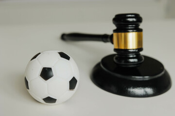 Soccer ball and judge gavel on the table. Corruption in football.