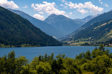 Artificial alpine reservoir lake Zoccolo Zoggler-Stausee and mountain range at Ultental, South Tyrol